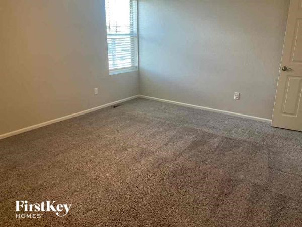an empty room with a carpeted floor and a window