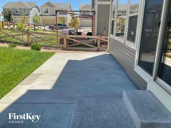 a backyard patio with concrete steps and a house