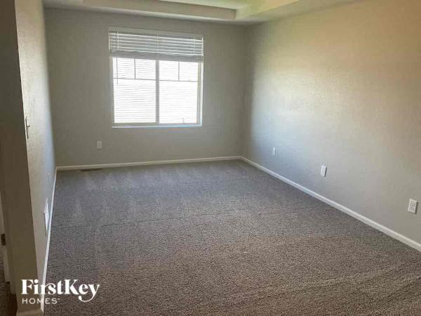 a large empty room with a window and carpet