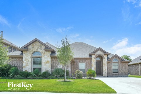a house with a lawn and a tree in front of it