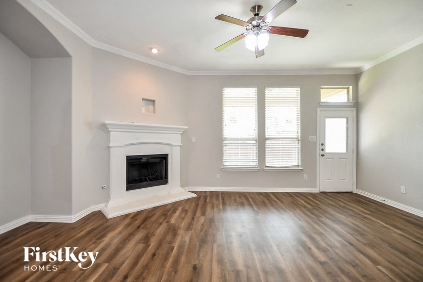 a living room with a fireplace and a ceiling fan