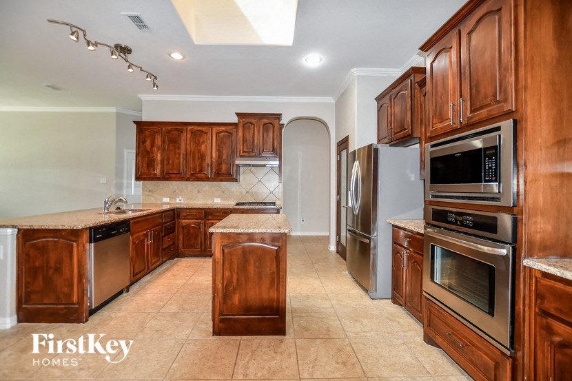 a kitchen with wooden cabinets and stainless steel appliances