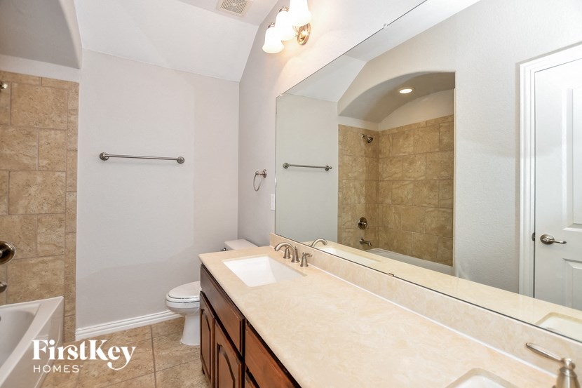 a bathroom with a large mirror and a sink and a toilet
