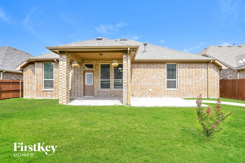 a small brick house with a lawn in front of it