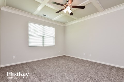 the master bedroom has a ceiling fan and a carpeted floor