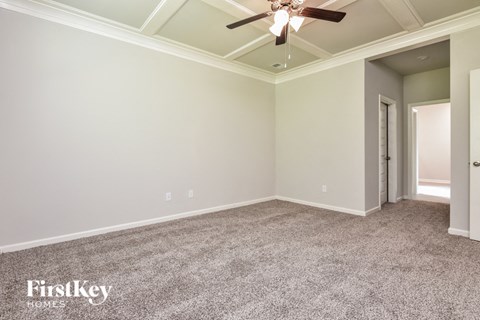 a living room with carpet and a ceiling fan