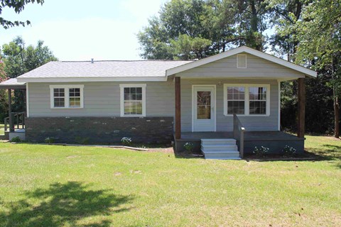 the front of the house with steps to the front yard