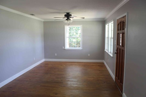 an empty room with a ceiling fan and a window