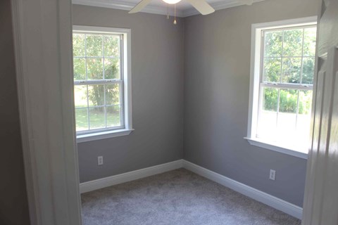 a corner of a room with two windows