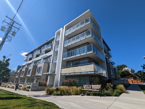 A modern apartment building with a clear blue sky above.