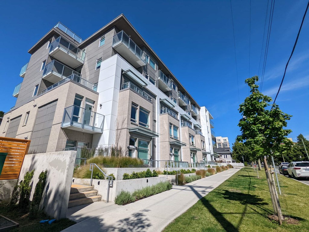 A modern apartment building with a clear blue sky above.