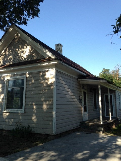 A small house with a brown roof and a white door.