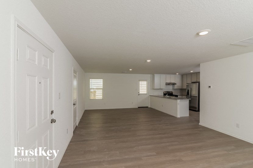 an empty living room and kitchen with a wood floor