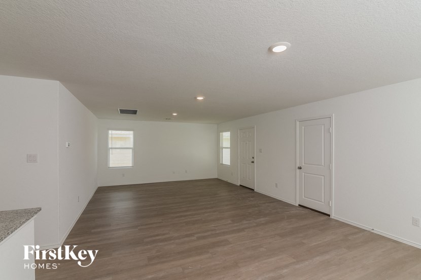 the living room and dining room of a house with a wood floor