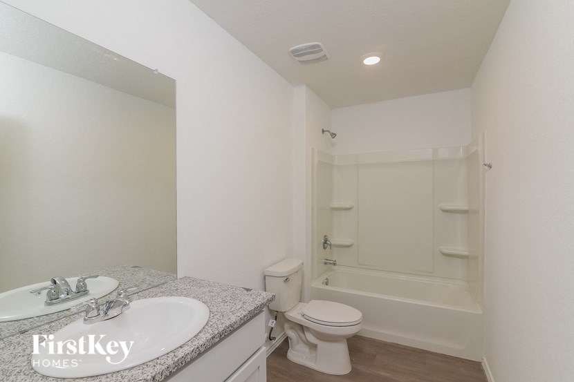 a bathroom with a toilet and a sink and a bath tub
