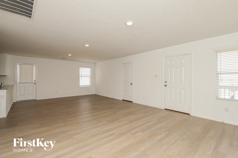 an empty living room with white walls and a wooden floor
