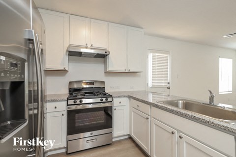 a kitchen with white cabinets and stainless steel appliances