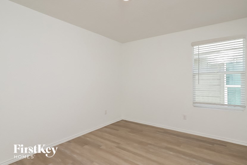 an empty room with a wood floor and a window