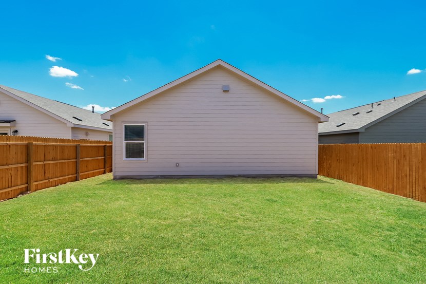 a backyard with a house and a wooden fence