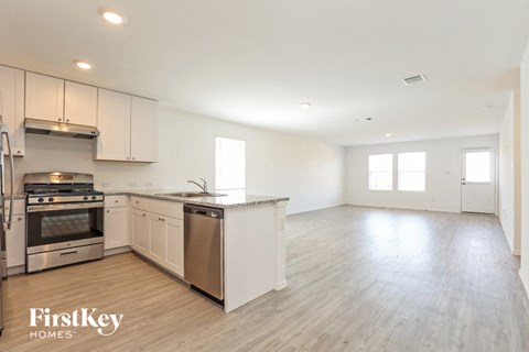A spacious kitchen with white cabinets and stainless steel appliances.