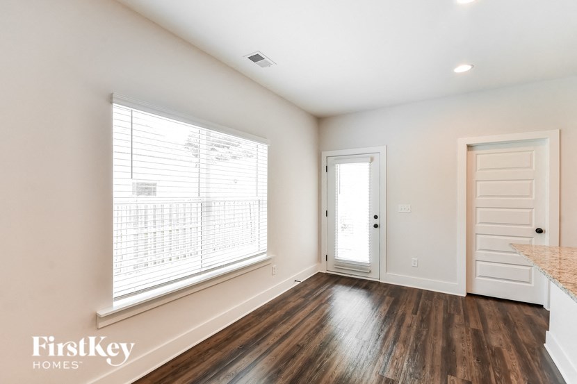 a living room with a large window and a door to a kitchen