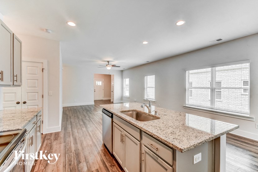 a kitchen and living room with a sink and a window