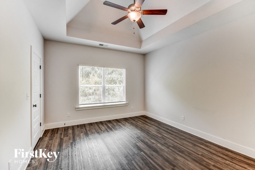 an empty room with a ceiling fan and a window