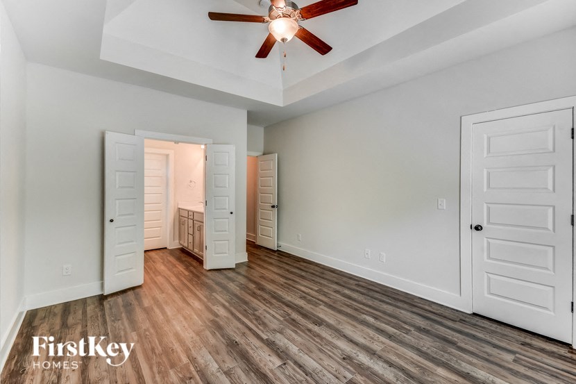 the living room of an empty house with a ceiling fan
