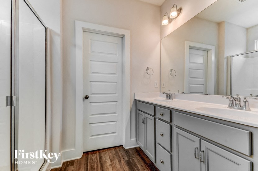 a bathroom with two sinks and a mirror and a closet