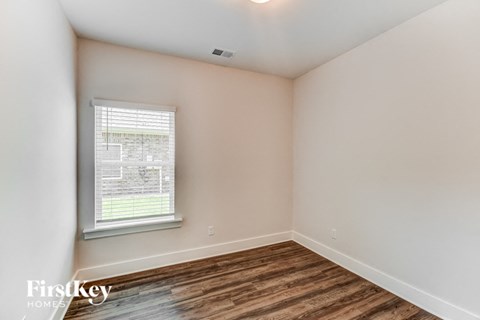 the living room of a home with a wood floor and a window