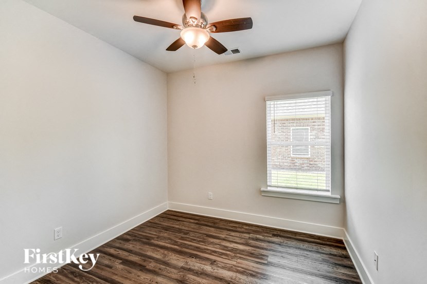 an empty room with a ceiling fan and a window