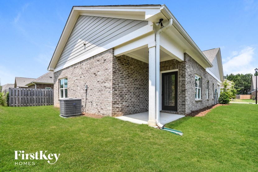 a brick house with a covered porch and a grass yard