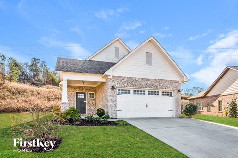 a home with a white garage door in front of a lawn