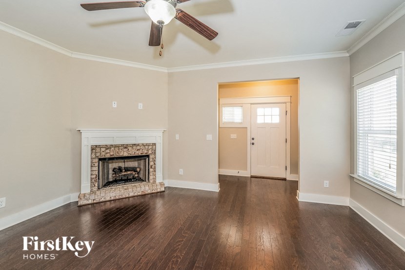 a living room with a fireplace and a ceiling fan