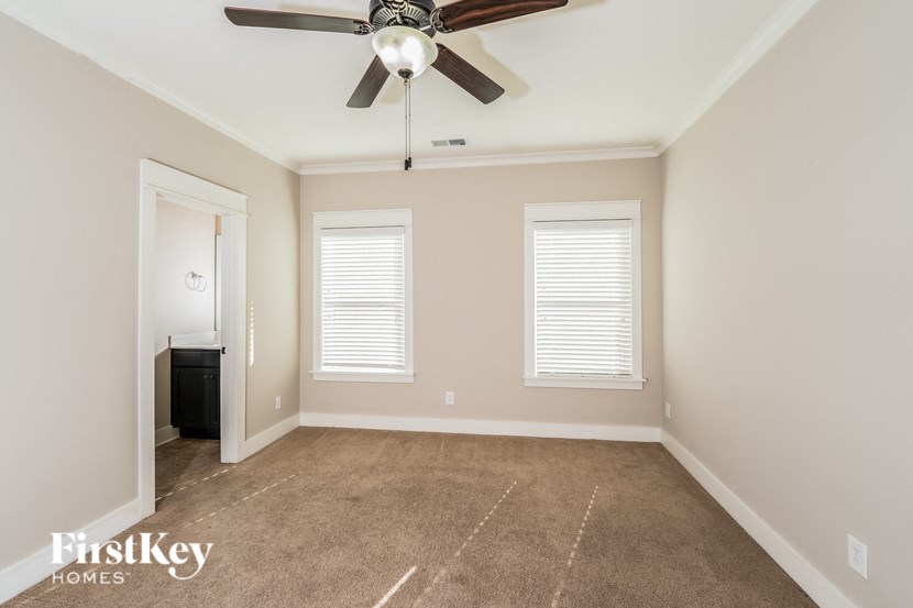 a empty room with a ceiling fan and two windows