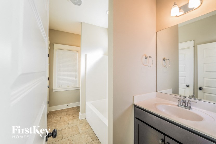 a bathroom with a sink and a shower and a mirror