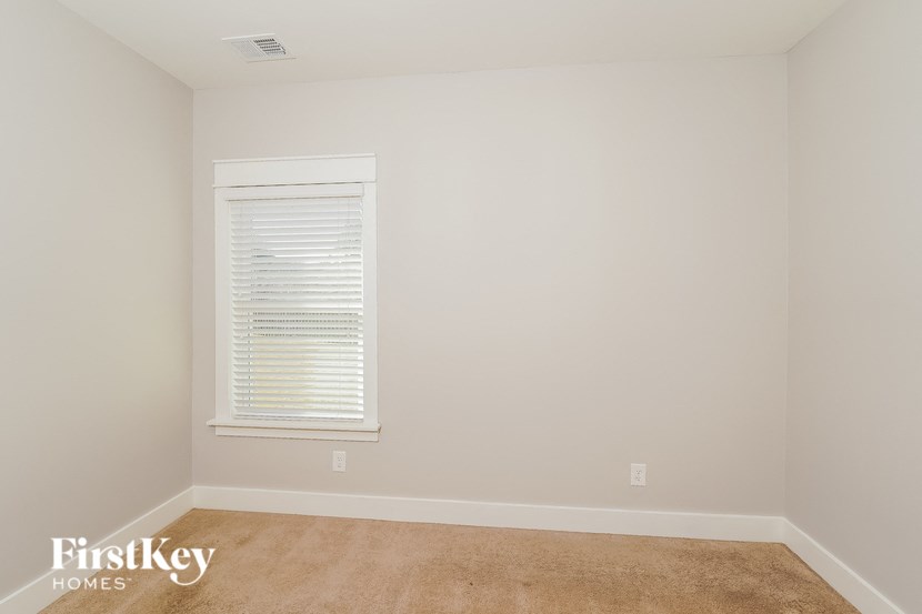 a room with white walls and a window and a carpet
