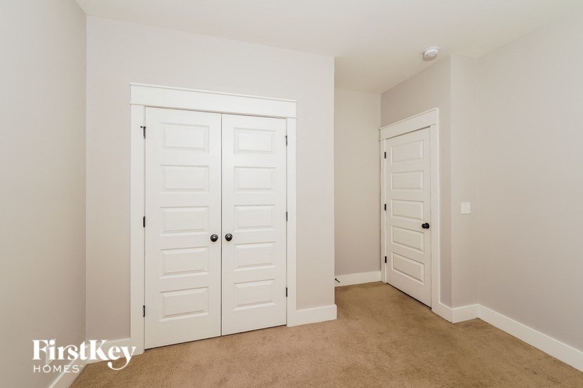 a bedroom with two closets and a carpeted floor