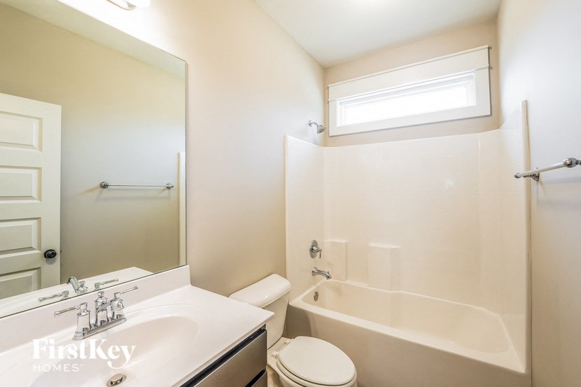 a white bathroom with a tub and a sink and a toilet