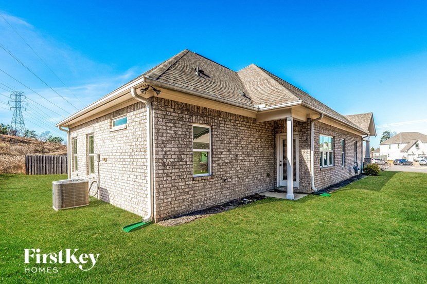 a brick home with green grass and a blue sky