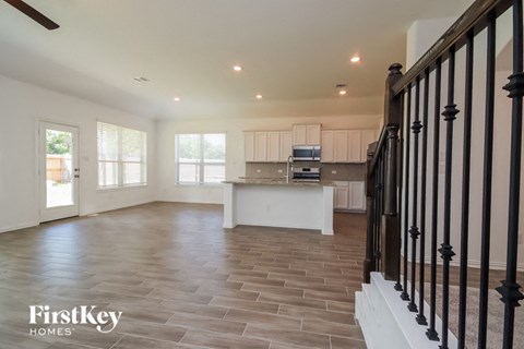 A spacious living room with a staircase on the right side.