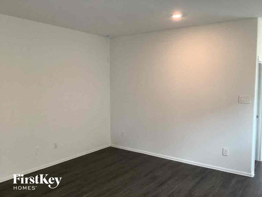 an empty room with white walls and wooden floors