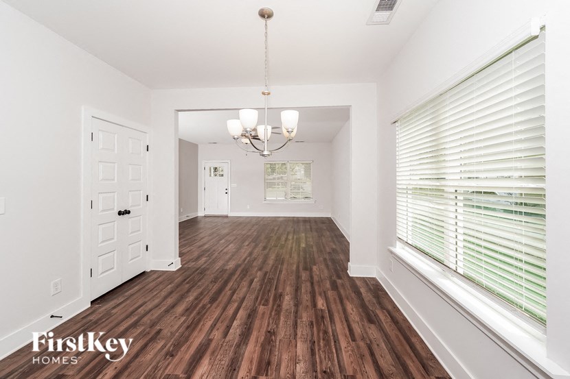 an empty living room with wood flooring and a large window