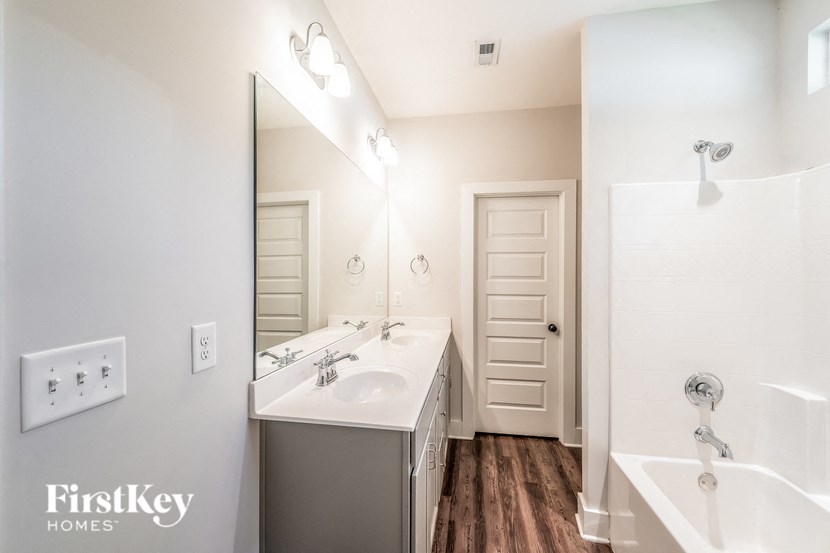 a bathroom with two sinks and a shower and a mirror