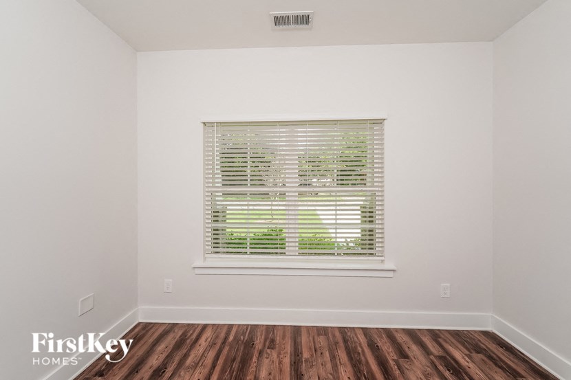 the living room of a home with a window and wood floors