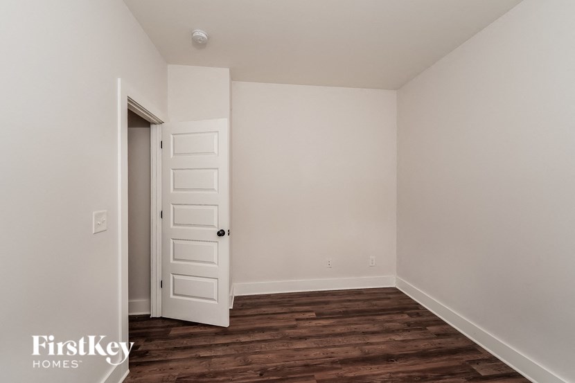 a bedroom with white walls and a closet and a white door