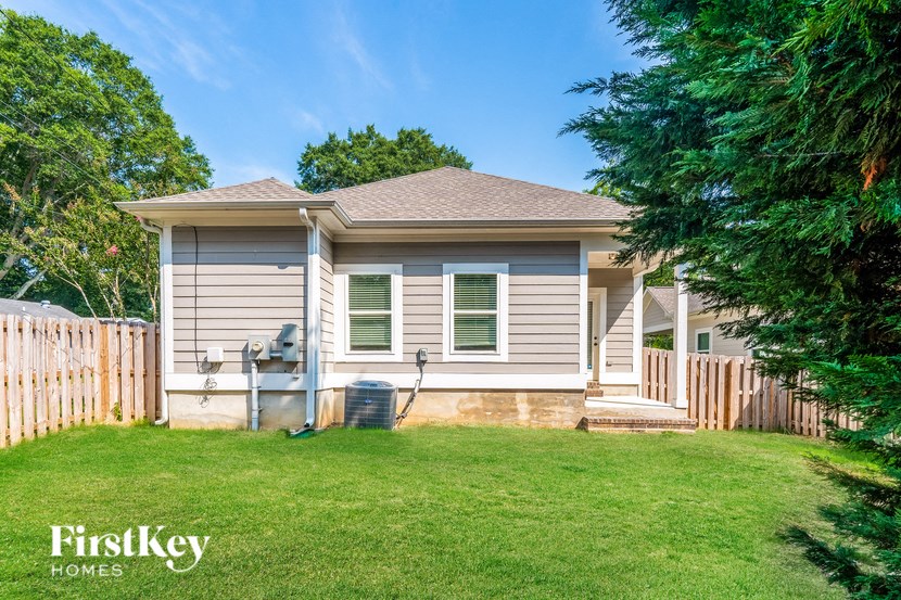 a small house with a lawn and a fence