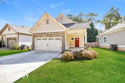 a white house with a white garage door and a lawn