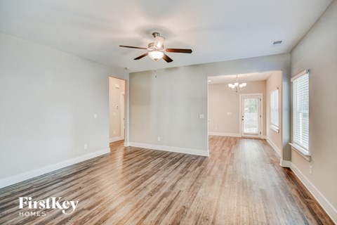 a living room with wood floors and a ceiling fan