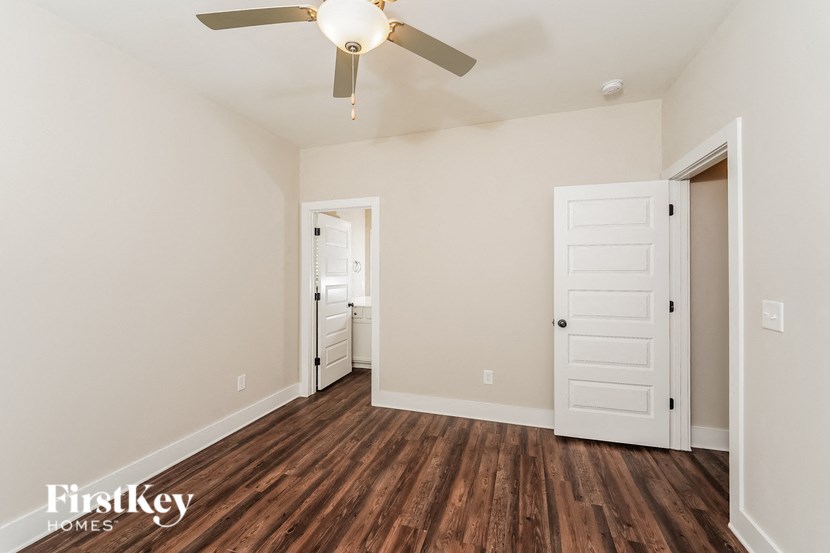 a living room with wood flooring and a ceiling fan